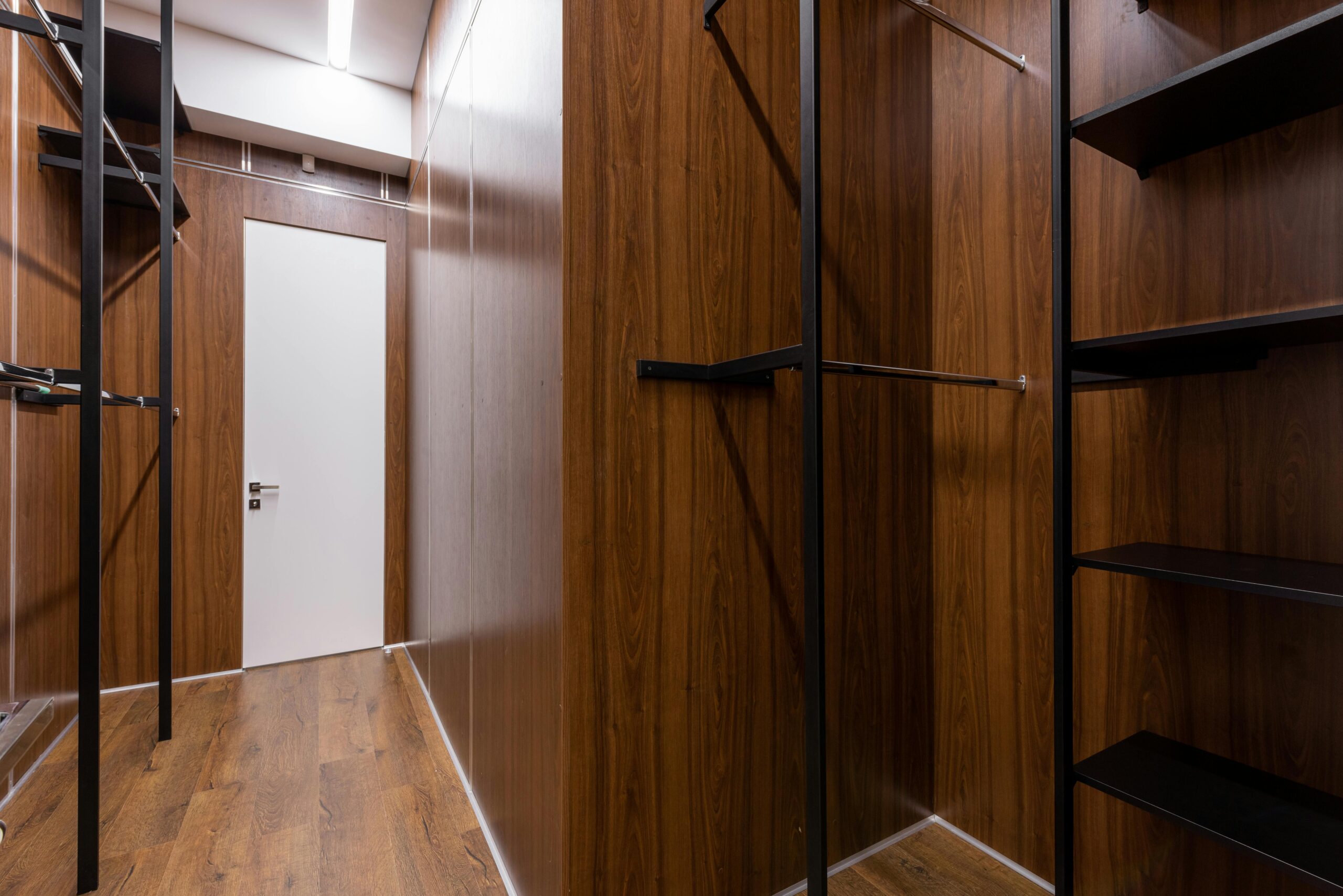 Wood-finished server or storage closet with adjustable metal rack supports and shelving.
